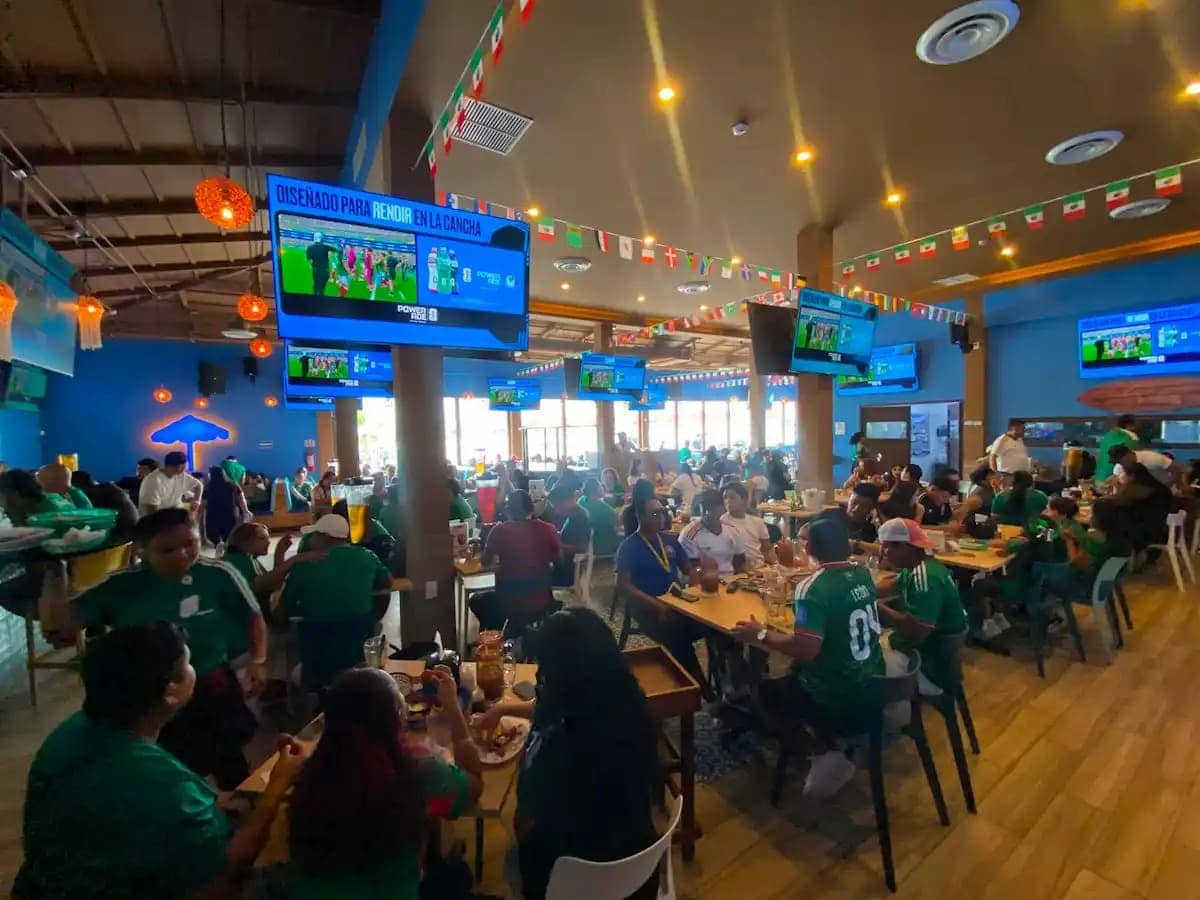 Clientes disfrutando de un partido de la Selección Mexicana en un restaurante de Cancún durante el Mundial 2026