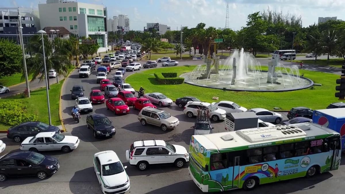 Tráfico vehicular en la Avenida Tulum de Cancún durante una jornada de lluvias intensas y calor